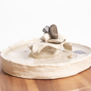 A handcrafted ceramic water bowl created during a Family Ceramic Experience, capturing a single droplet falling into the water and creating serene ripple