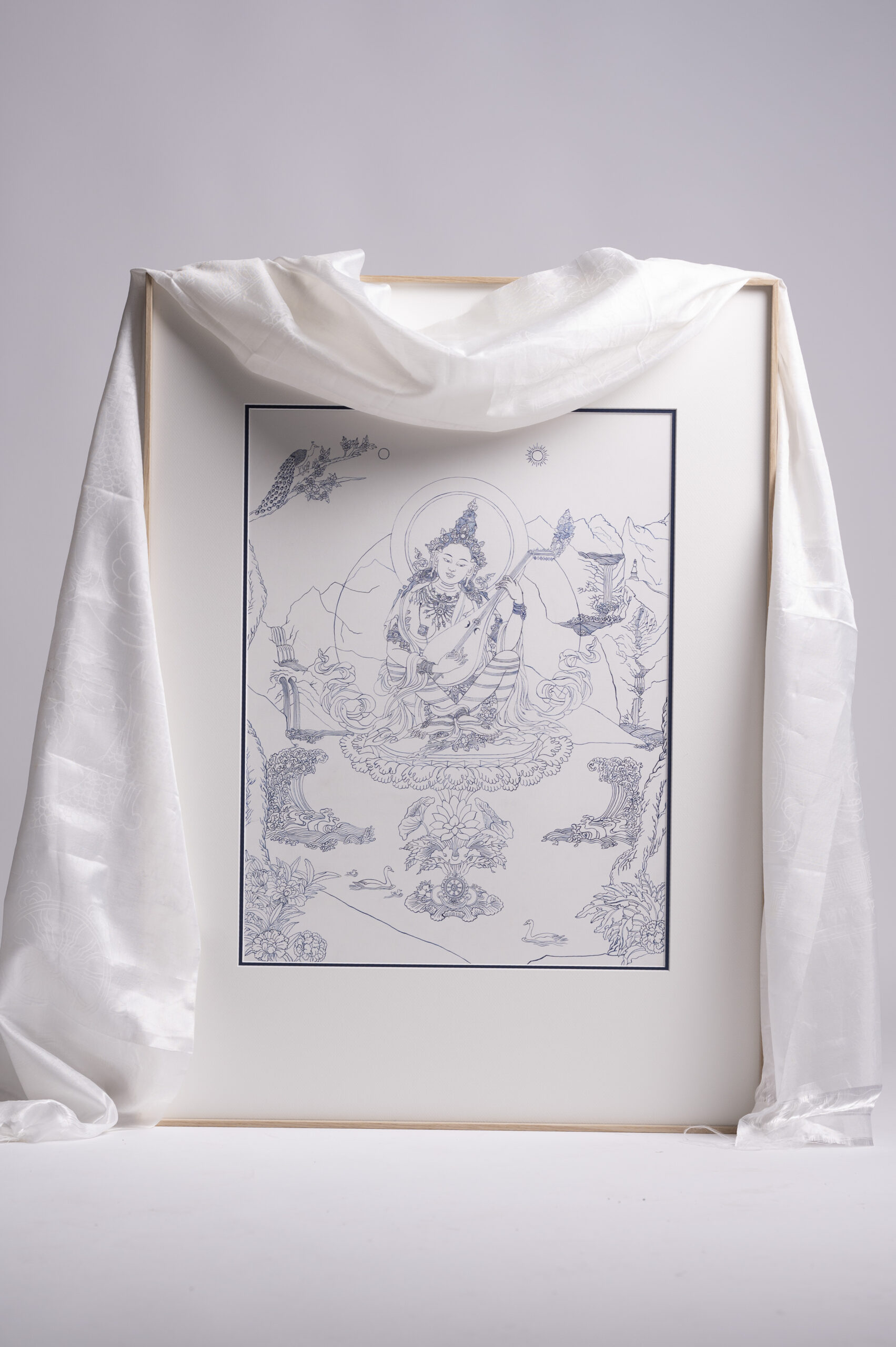 The original hand-painted Sarasvati Thangka artwork, elegantly displayed with the traditional white Khata silk scarf used to bless the sacred painting